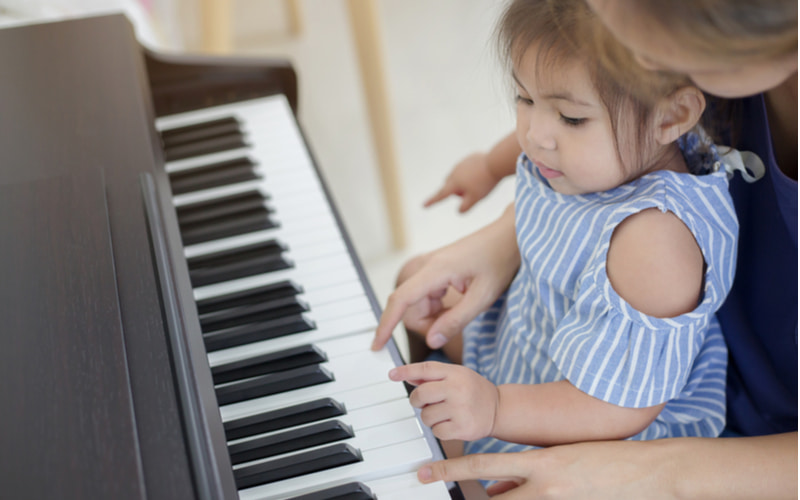 Bé 1 tuổi chơi đàn giúp phát triển tư duy.  (Ảnh: Shutterstock.com)